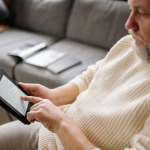 Man sitting on a sofa using an electronic tablet