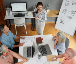 People in a meeting sat around a table with laptops